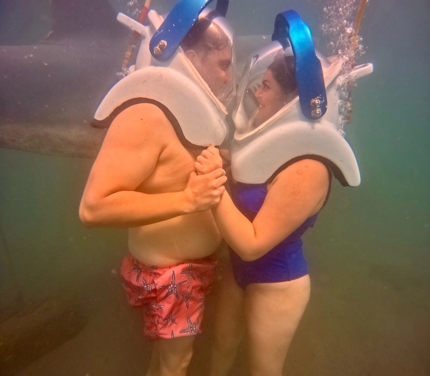 Pareja tomándose de las manos durante la caminata submarina